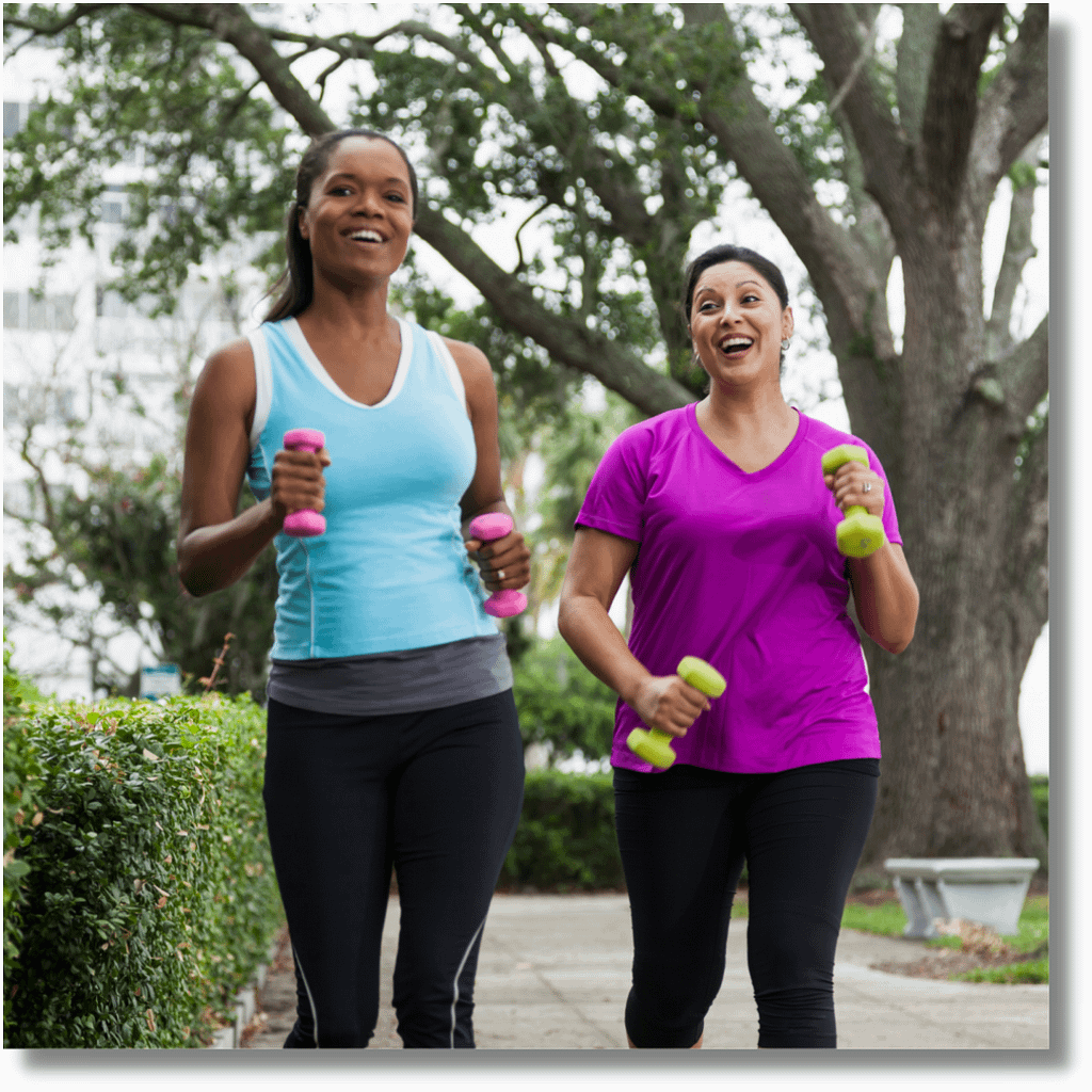 Women smiling and exercising using dumbbells