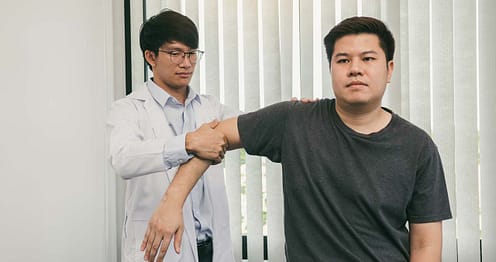 guy doctor stretching his client's arm outwards